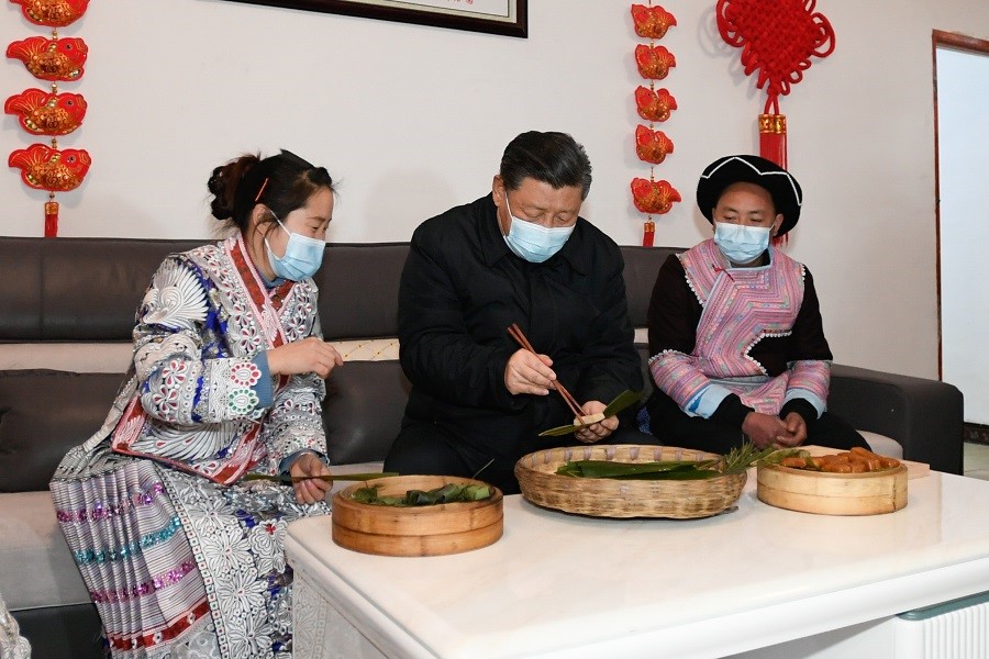 2021年2月3日下午，習(xí)近平在貴州畢節(jié)市黔西縣新仁苗族鄉(xiāng)化屋村苗族村民趙玉學(xué)家，同一家人邊聊家常邊制作當(dāng)?shù)貍鹘y(tǒng)節(jié)日食品黃粑。新華社記者 李學(xué)仁 攝